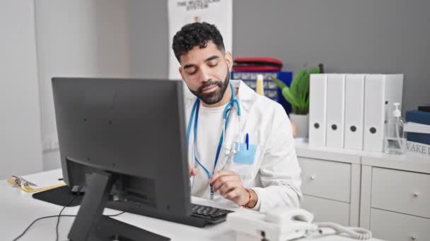 Ung Latinamerikansk Man Läkare Talar Telefon Med Hjälp Dator Kliniken — Stockvideo