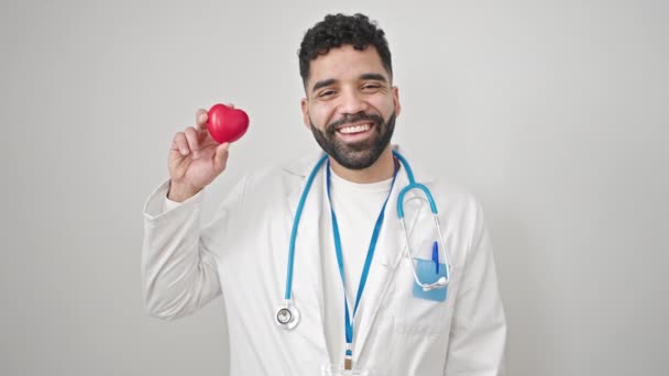 Jeune Homme Hispanique Médecin Souriant Tenant Coeur Sur Fond Blanc — Video