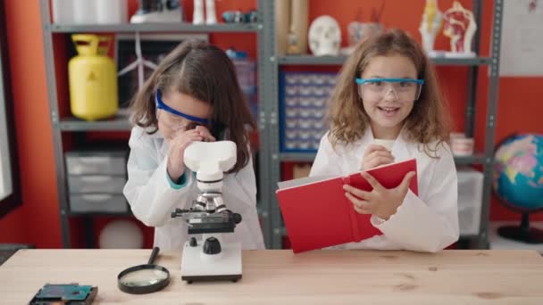 Αξιολάτρευτα Κορίτσια Μαθητές Που Χρησιμοποιούν Σημειώσεις Γραφής Μικροσκοπίου Στην Τάξη — Αρχείο Βίντεο