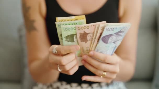 韓国を数える若い女性は家で紙幣を獲得した — ストック動画