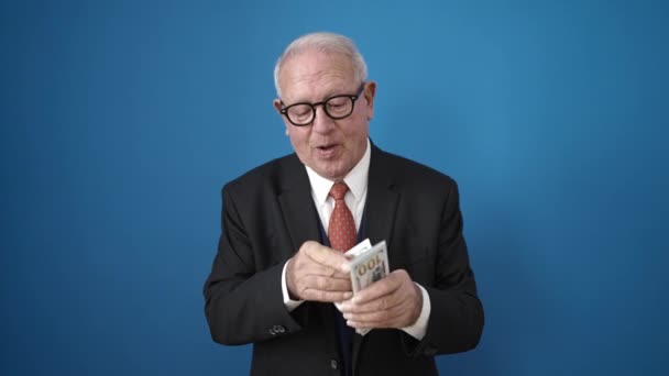 Senior Lächelnd Dollar Zählend Über Isoliertem Blauem Hintergrund — Stockvideo