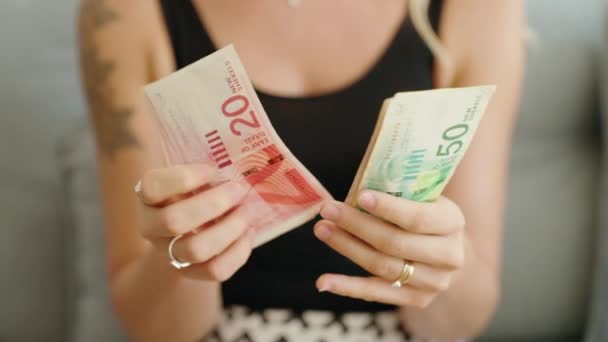 イスラエル シェケルの銀行券を家に数える若い女性 — ストック動画