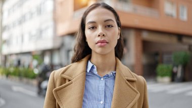 Sokakta ciddi bir ifadeyle duran genç, güzel İspanyol kadın.