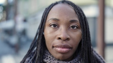 African woman standing with serious expression at street