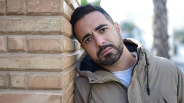 Sokakta ciddi bir ifadeyle duran İspanyol genç adam.