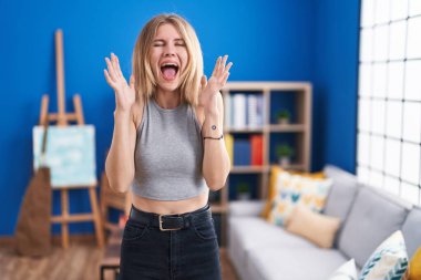 Sarışın, beyaz bir kadın oturma odasında kollarını kaldırmış ve gözleri kapalı heyecanla haykırarak başarının çılgınlığını kutluyor. Kazanan konsept 