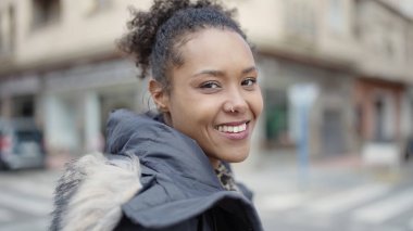 Sokakta kendine güvenen Afrikalı Amerikalı kadın gülümsüyor