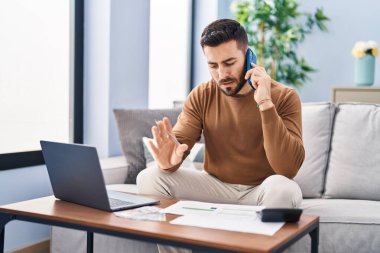 Genç İspanyol muhasebe ekonomisi evdeki akıllı telefondan konuşuyor.