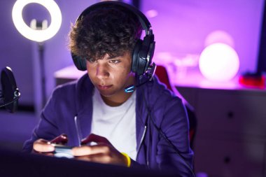 Oyun odasında joystick kullanarak video oyunu oynayan İspanyol asıllı bir genç.