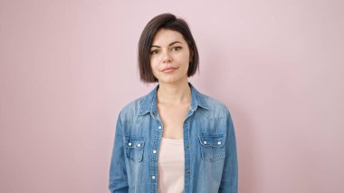 İzole edilmiş pembe arka planda kendine güvenen beyaz kadın.