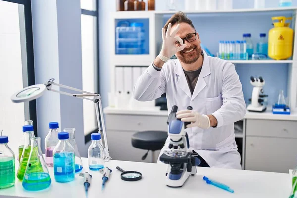 中年白种人在科学家实验室工作时 微笑着快乐地做着工作 手拿着手签 用手指看东西 — 图库照片