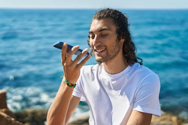 Young Hispanic Man Talking Smartphone Sitting Rock Seaside — Stock Photo, Image