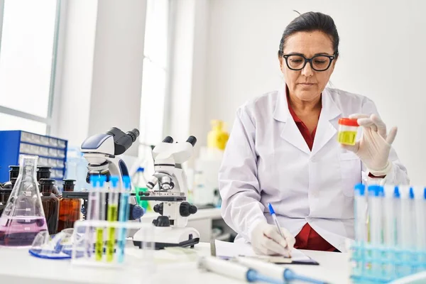 Middle Age Hispanic Woman Wearing Scientist Uniform Analysing Urine Test — Stock fotografie