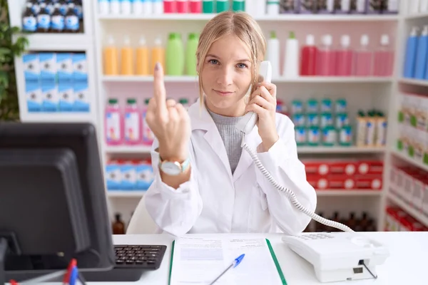 Young Caucasian Woman Working Pharmacy Drugstore Speaking Telephone Showing Middle — Stok fotoğraf