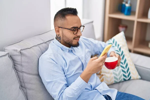 Young Hispanic Man Drinking Coffee Using Smartphone Home — Photo