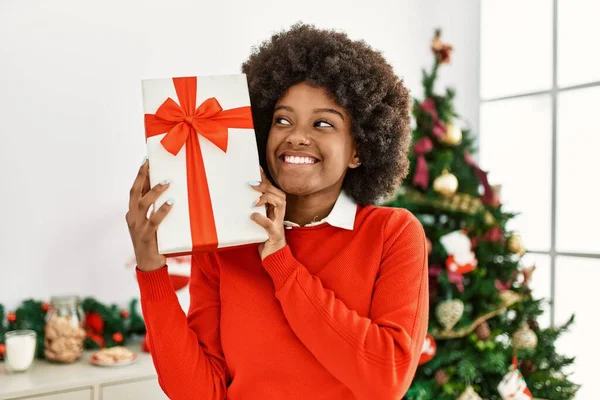 Joven Mujer Afroamericana Sosteniendo Regalo Pie Junto Árbol Navidad Casa —  Fotos de Stock