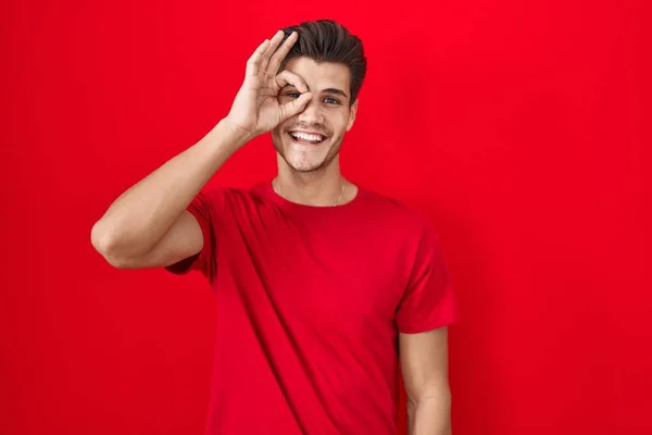 Молодий Іспаномовний Чоловік Стоїть Червоному Тлі Робить Нормальний Жест Посмішкою — стокове фото