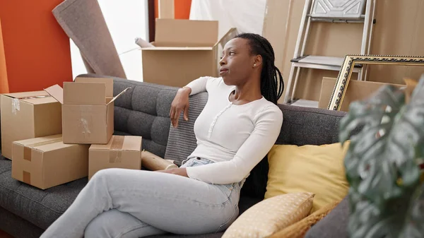 Африканская Американка Сидящая Диване Расслабленным Лицом Новом Доме — стоковое фото