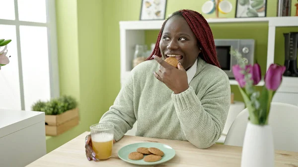 Mulher Africana Com Cabelo Trançado Comer Biscoito Sentado Mesa Sala — Fotografia de Stock