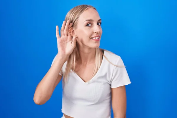 Young Caucasian Woman Standing Blue Background Smiling Hand Ear Listening — Fotografia de Stock