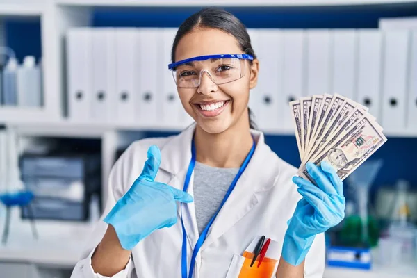 Молодая Бразильская Женщина Работающая Научной Лаборатории Держит Деньги Указывая Пальцем — стоковое фото