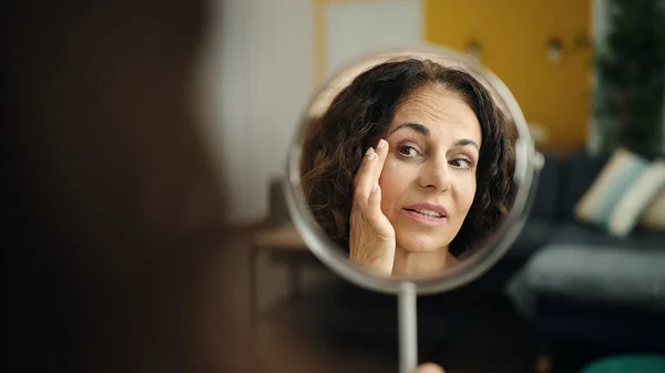 Middle Age Hispanic Woman Sitting Sofa Looking Face Mirror Home —  Fotos de Stock