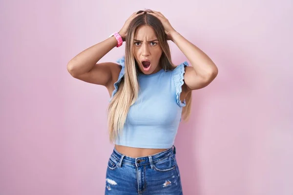 Young Blonde Woman Standing Pink Background Crazy Scared Hands Head — Stockfoto