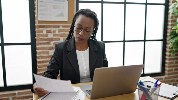 Αφροαμερικάνα Επιχειρηματίας Χρησιμοποιώντας Έγγραφο Ανάγνωσης Laptop Στο Γραφείο — Φωτογραφία Αρχείου