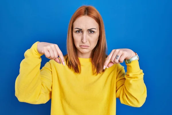 Young Woman Standing Blue Background Pointing Looking Sad Upset Indicating —  Fotos de Stock