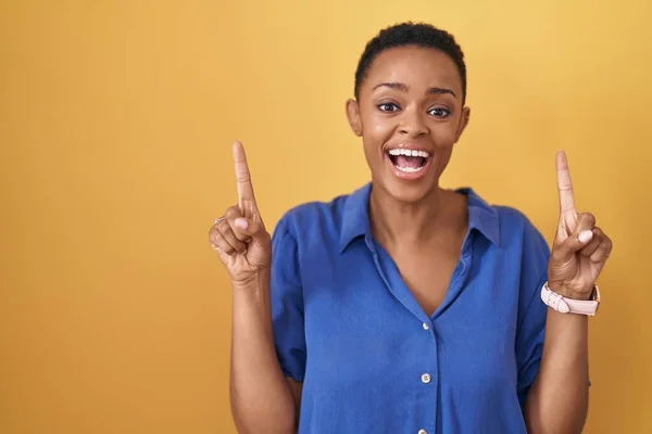 Africano Americano Mulher Sobre Fundo Amarelo Sorrindo Espantado Surpreso Apontando — Fotografia de Stock