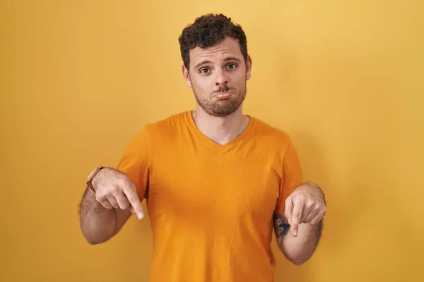 Young Hispanic Man Standing Yellow Background Pointing Looking Sad Upset — 스톡 사진