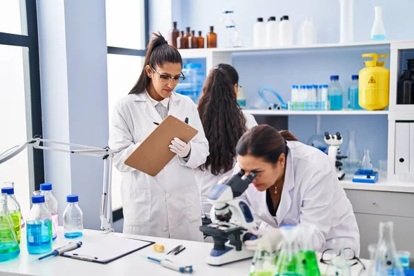 Three Woman Scientists Using Microscope Write Checklist Laboratory — Stock Photo, Image
