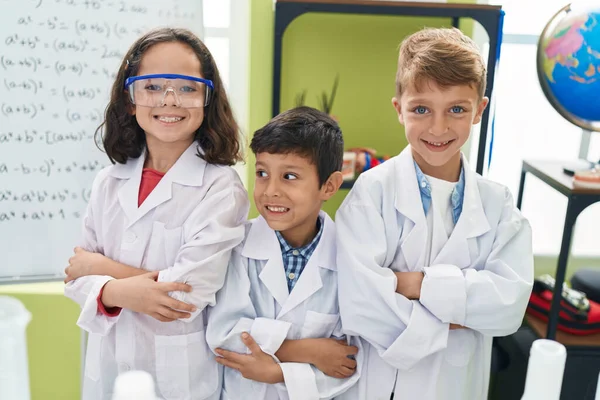 子供たちのグループ研究室の教室で腕を組んで自信を持って立って笑顔科学者 — ストック写真