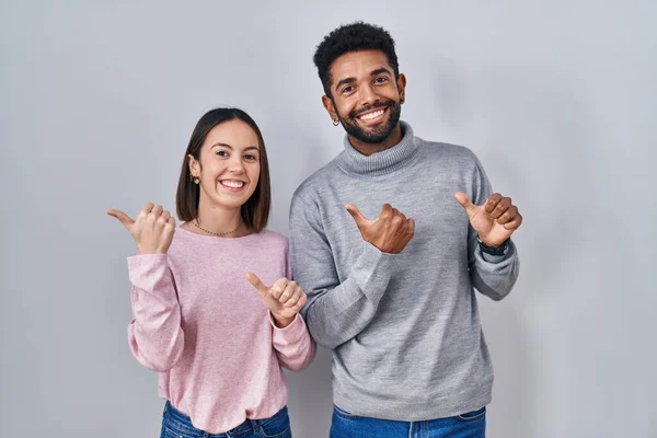 Jong Hispanic Paar Samen Staan Wijzen Naar Achterkant Met Hand — Stockfoto