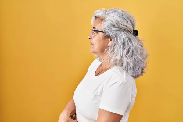 Sarı Arka Planda Duran Gri Saçlı Orta Yaşlı Kadın Yan — Stok fotoğraf