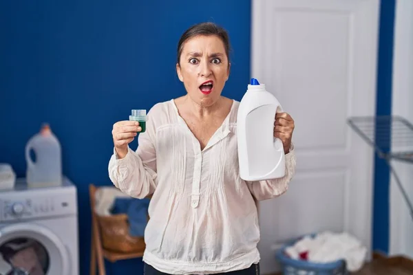 Middle Age Hispanic Woman Holding Detergent Bottle Shock Face Looking — Stok fotoğraf