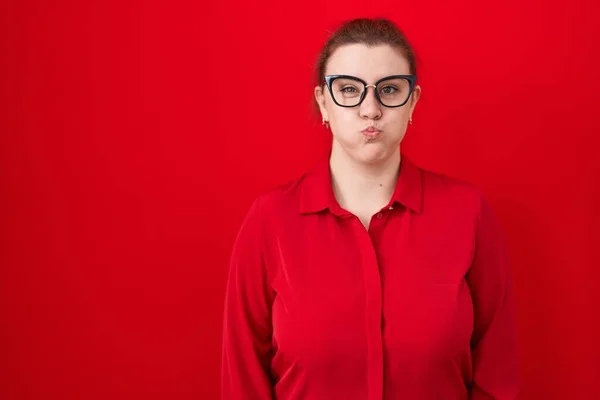 Young Hispanic Woman Red Hair Standing Red Background Puffing Cheeks — Stock Photo, Image