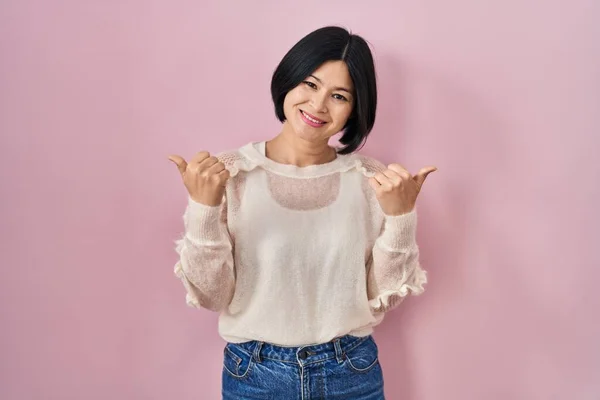 배경의 아시아인 여성은 손으로 긍정적 몸짓을 손가락으로 웃으며 행복하게 웃는다 — 스톡 사진
