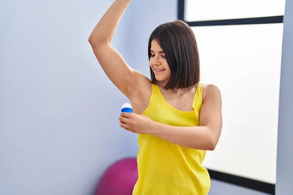 Young Beautiful Hispanic Woman Applying Deodorant Sport Center — Stock Photo, Image
