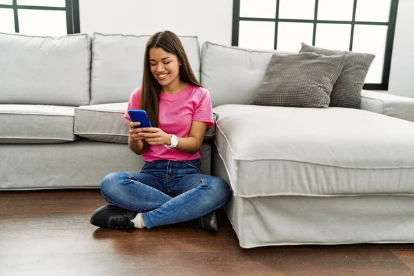 Genç Latin Kadın Akıllı Telefon Kullanıyor Evde Yerde Oturuyor — Stok fotoğraf