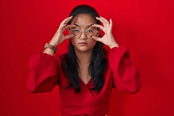 Azji Młoda Kobieta Stojąca Czerwonym Tle Próbuje Otworzyć Oczy Palcami — Zdjęcie stockowe