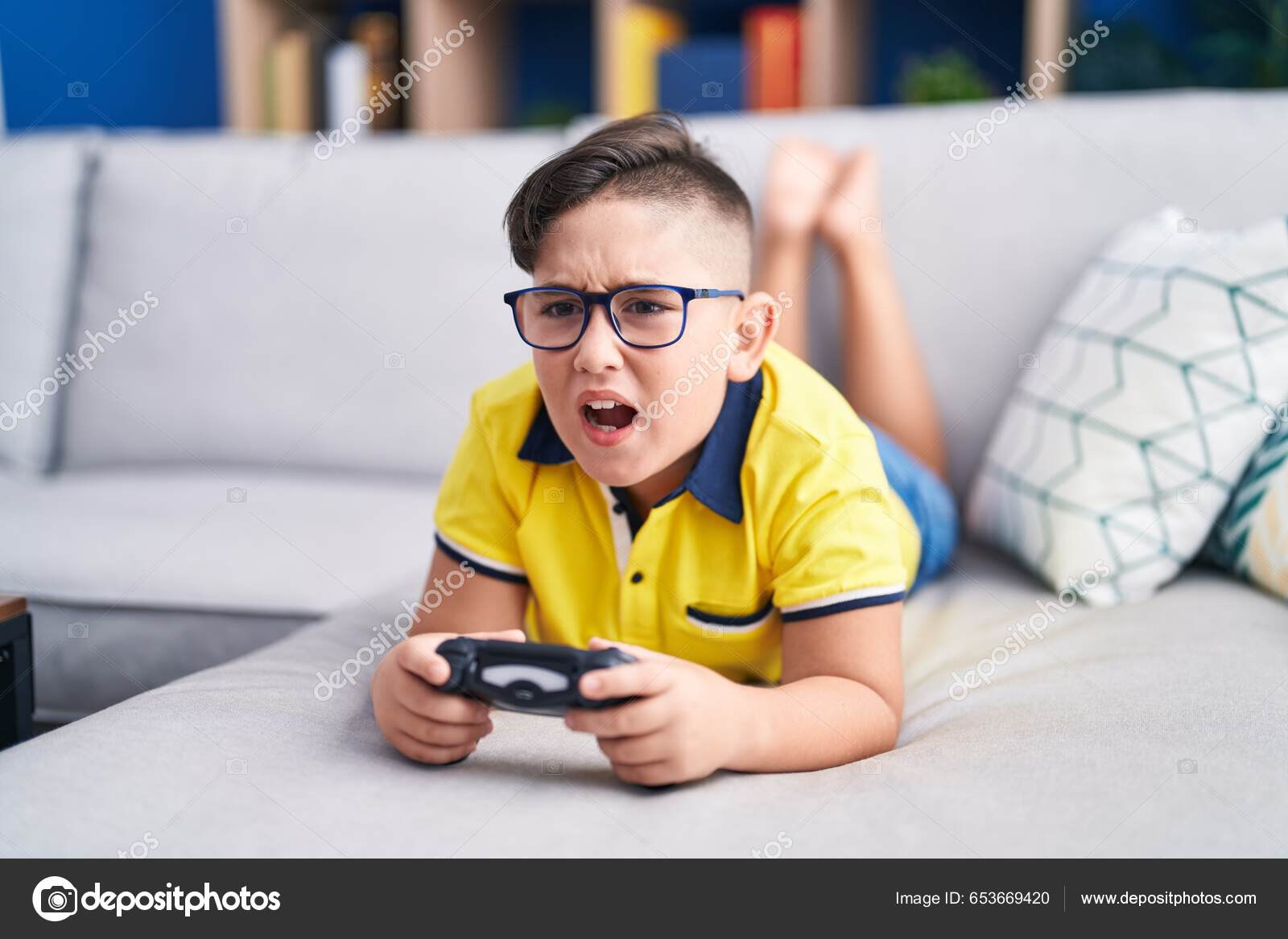 Young Hispanic Kid Playing Video Game Holding Controller Sofa