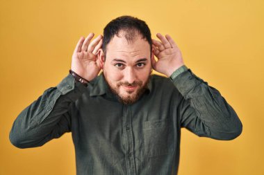 Ayrıca sarı arka planda duran sakallı, iki elini de kulak hareketi yaparken duymaya çalışan, dedikoduya meraklı İspanyol bir adam. İşitme sorunu, sağır 