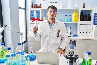 Laboratuvarda çalışan Latin asıllı genç bir adam. Diploma sahibi. Düşünce tarzı ve ayık ifadesi. 