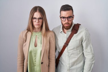 Beyaz arka planda duran genç çift şüpheci ve gergin, sorun yüzünden üzgün. negatif kişi. 