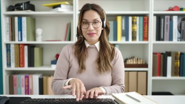 Genç ve güzel İspanyol öğrenci kütüphane üniversitesinde video görüşmesi yapıyor.