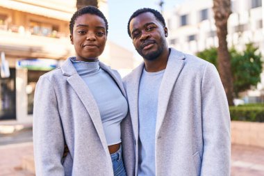 Erkek ve kadın bir arada durarak gülümsüyor.