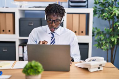 Çağrı merkezi kulaklığı takan Afrikalı bir adam kamerayı işaret ediyor ve sen kendine güvenen ciddi bir hareket yapıyorsun. 