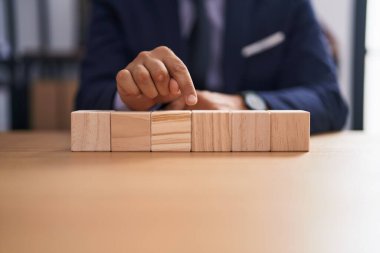 Ofiste tahta küplerle masada oturan genç latin iş adamı.