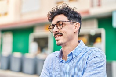 Young caucasian man smiling confident looking to the side at street